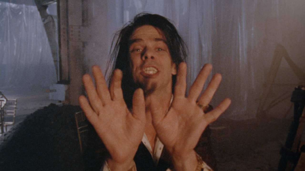 Nick Cave holding his hands up
